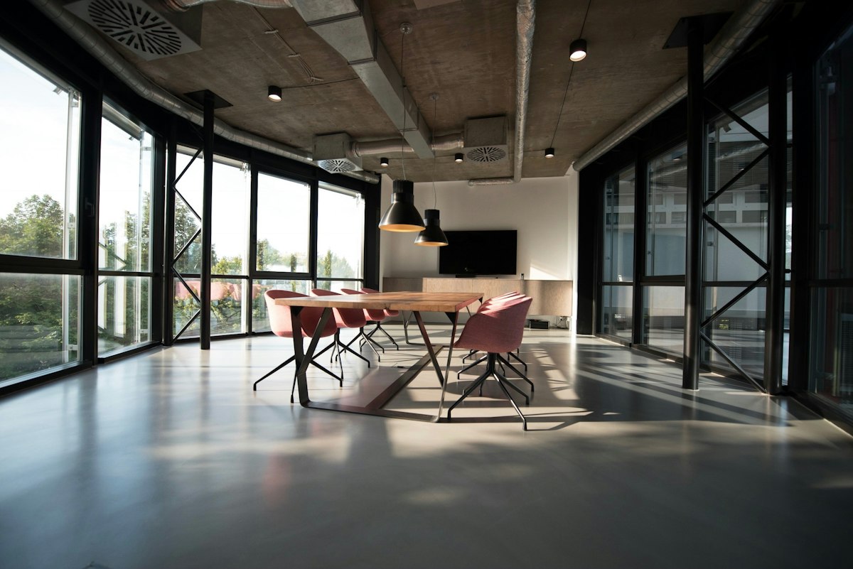 Light-filled professional workspace with shared tables and meeting areas